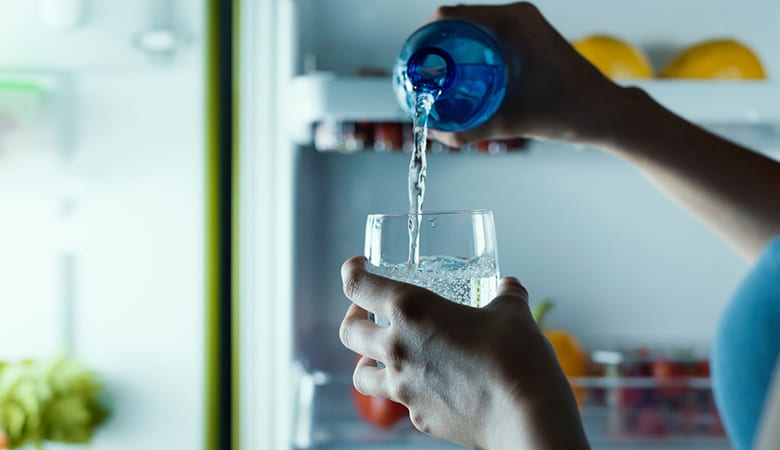 A person is pouring water into a glass.