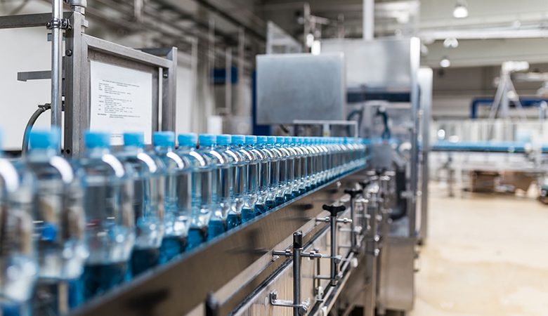 A line of bottled water on the conveyer belt.