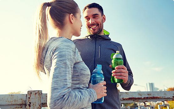 A man and woman holding bottles of water.