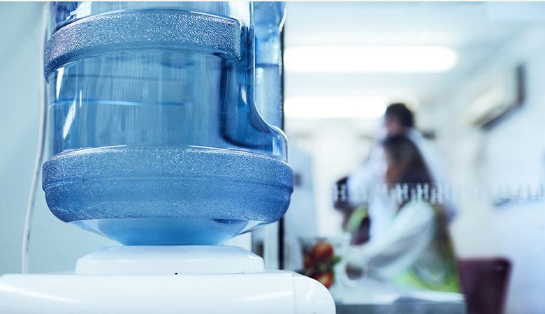 A close up of a water bottle on top of a cooler